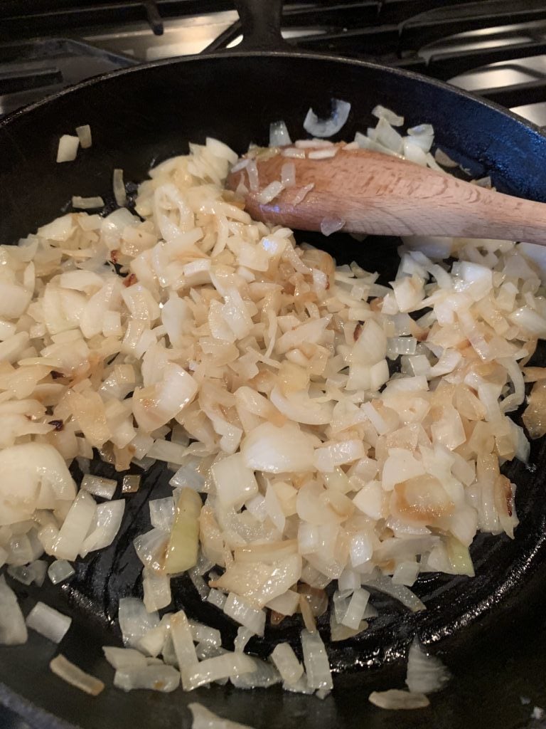 Onions sautÃ©ing in a skillet.