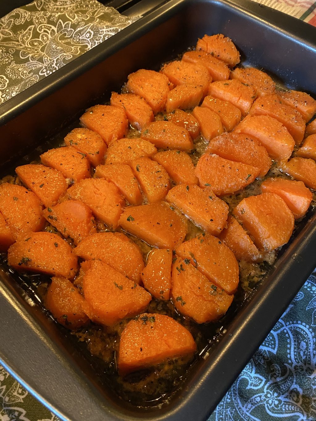 Cooked slices of sweet potato in a baking pan.