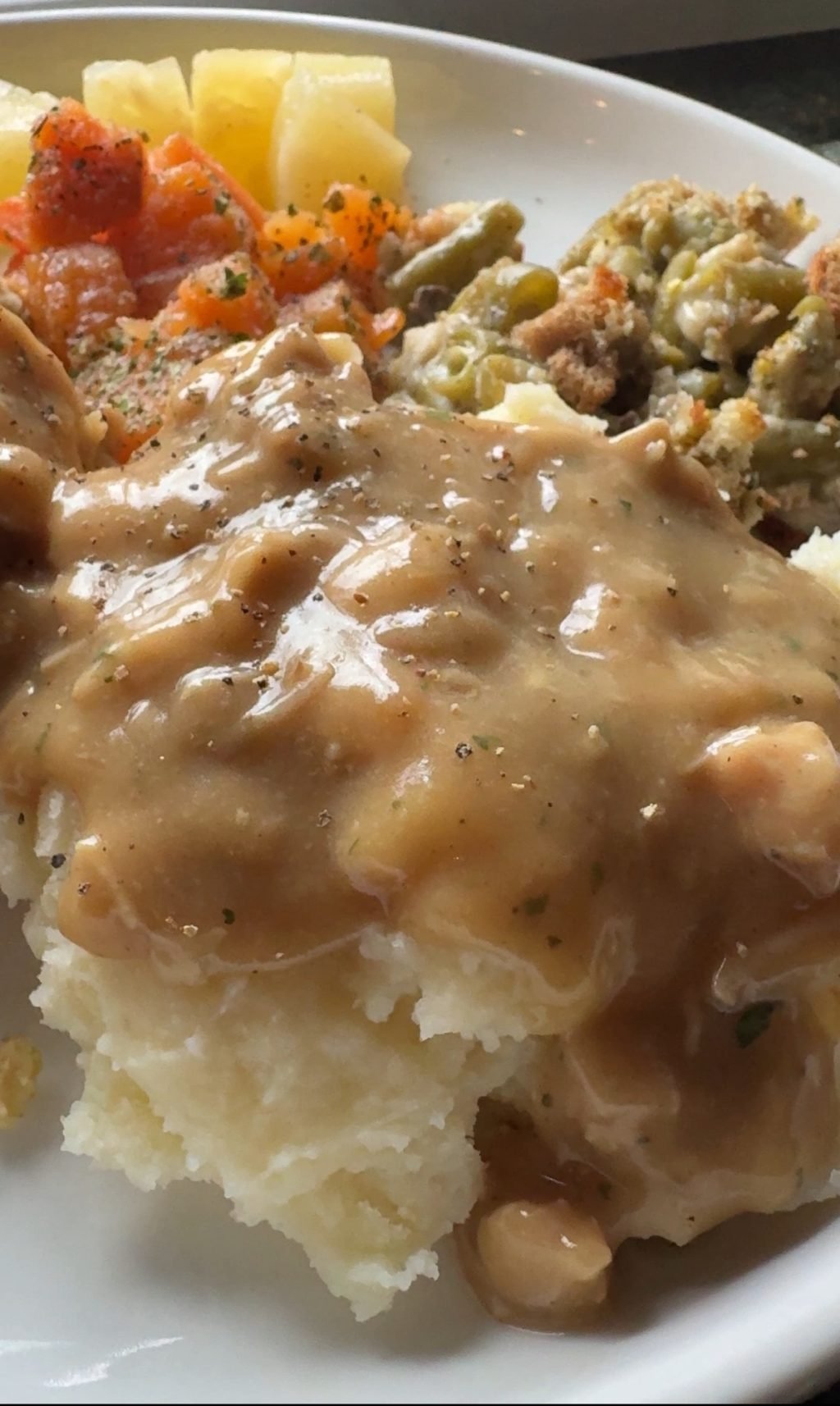 A close up of mashed potatoes covered in gravy.