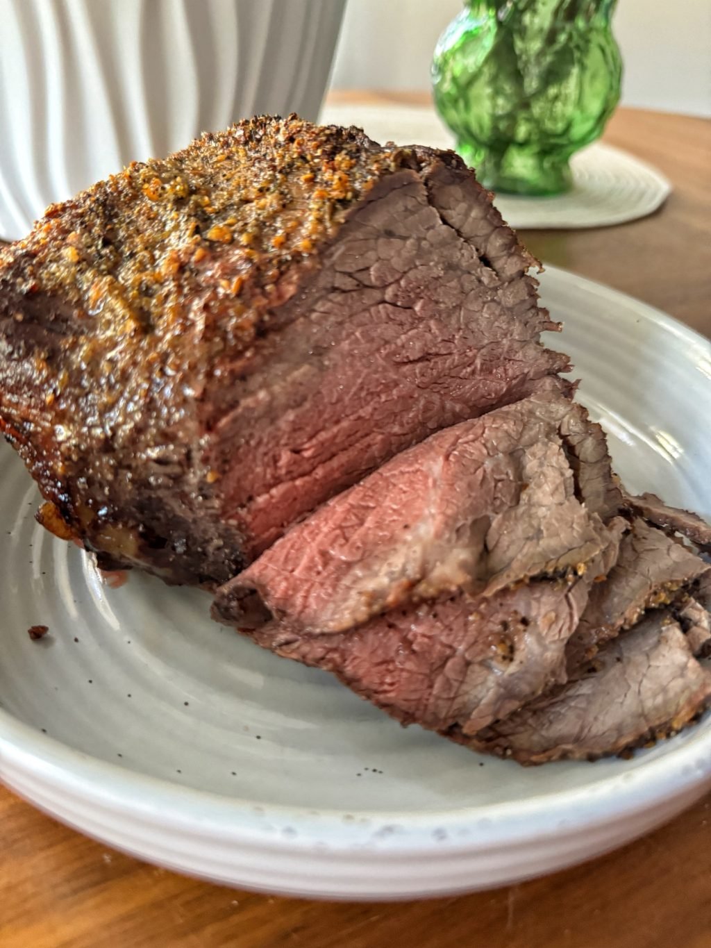 Sliced holiday beef roast on a white plate.