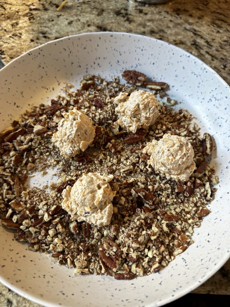 Crushed pecans with four cheese balls on top.