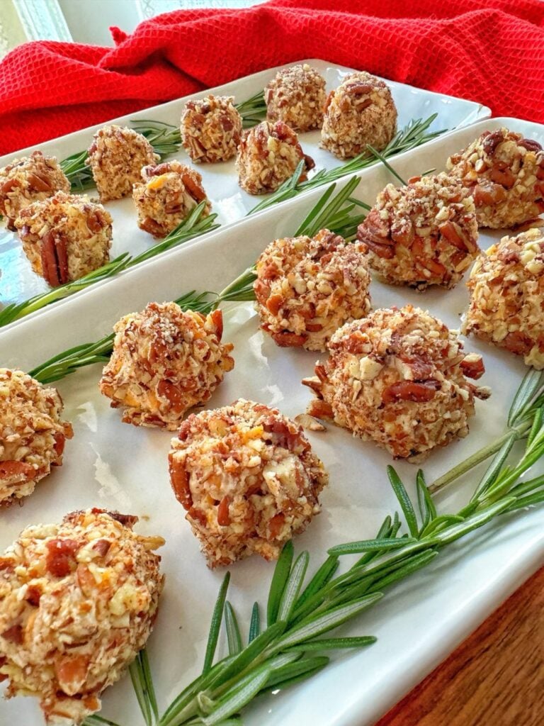 Cheese ball appetizers on a rectangular white plate.