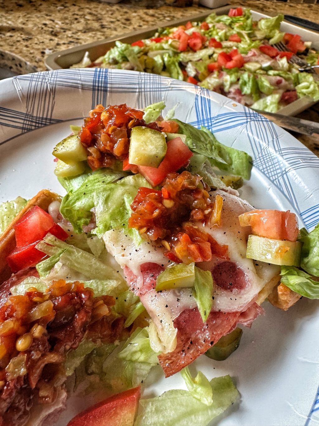 A piece of cold cut combo with veggies on a pate