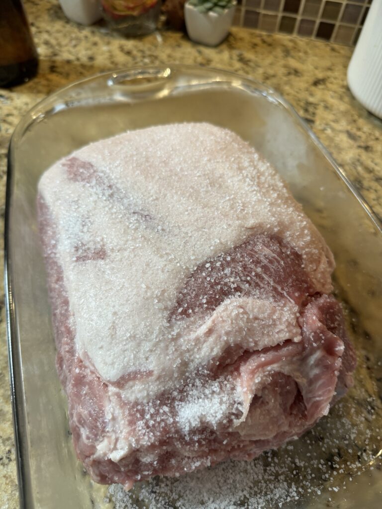 Salted raw pork roast in a glass baking dish