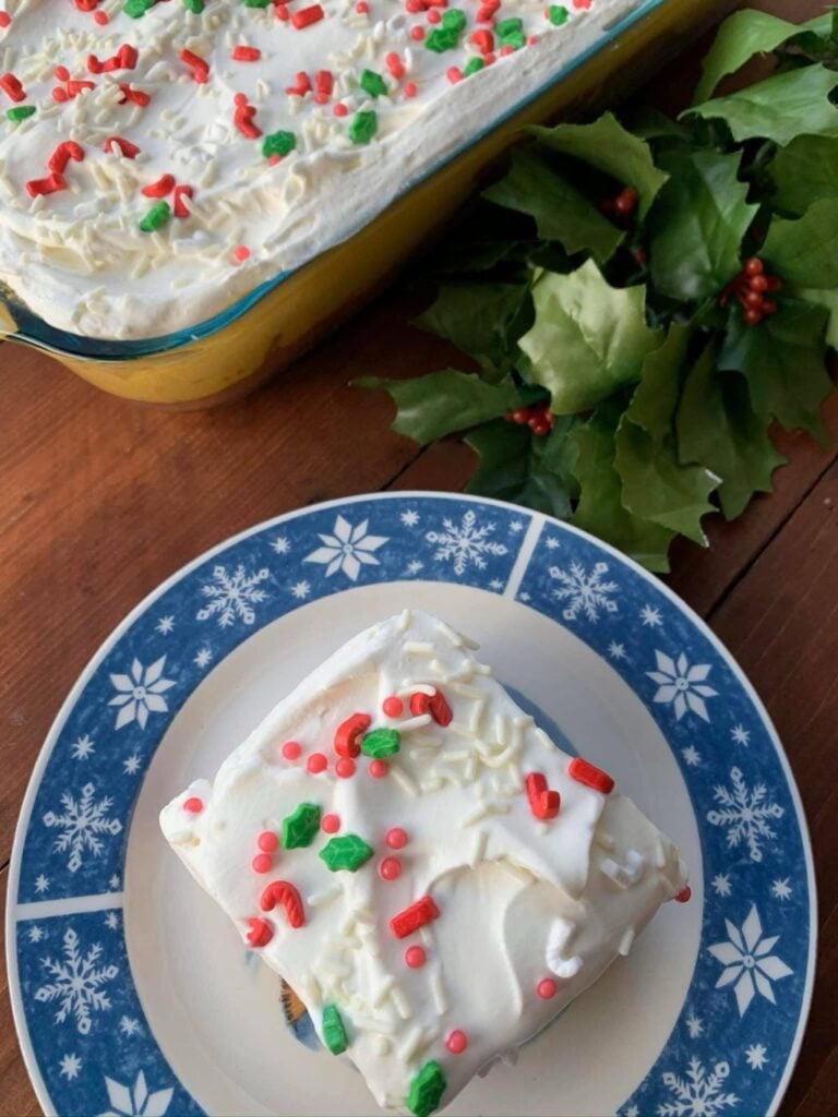 A slice of egg nog layer cake on a white and blue plate