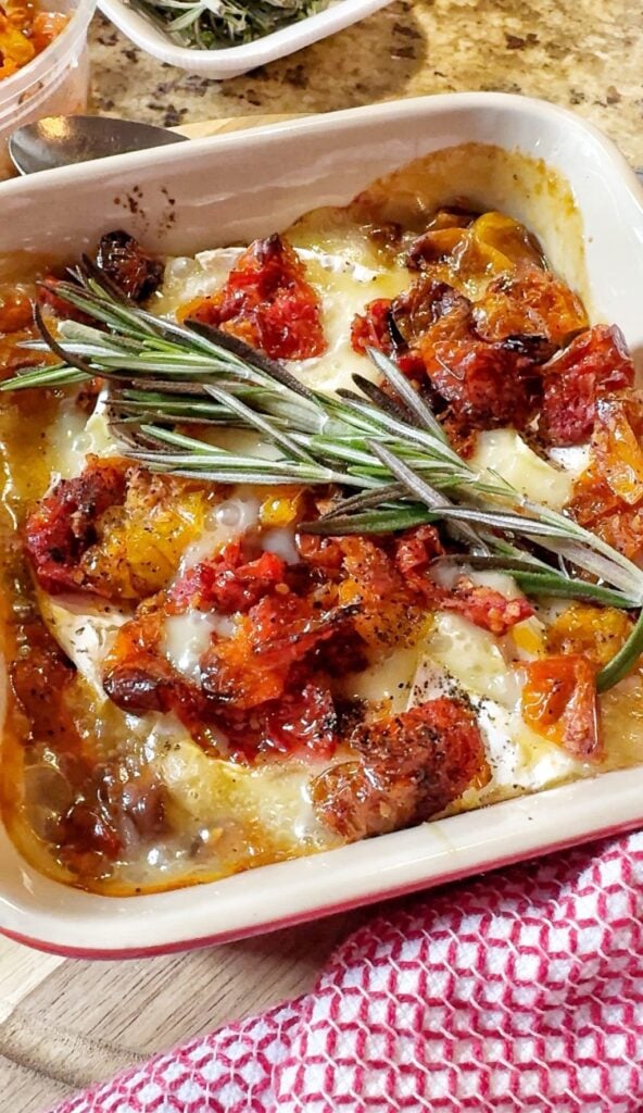 Sweet and savory baked brie with a sprig of Rosemary on top