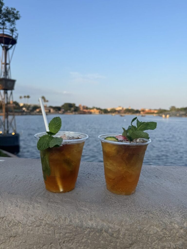 Two Pimm's Cup drinks on a ledge overlooking a body of water