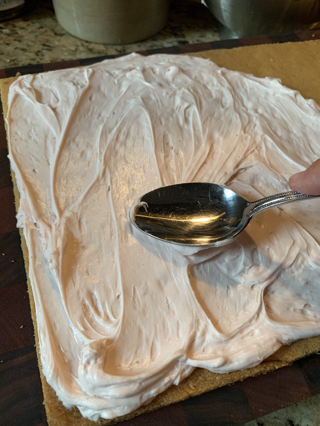 Spoon spreading cream cheese