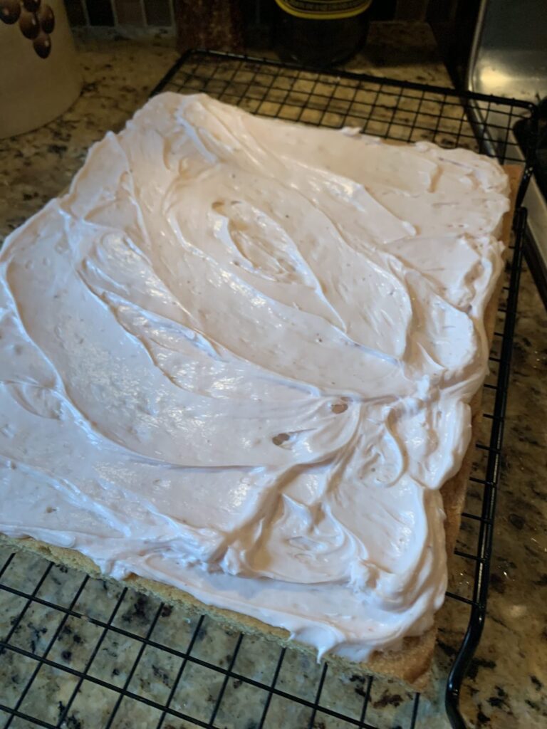 The cookie dough with the cream cheese spread over it
