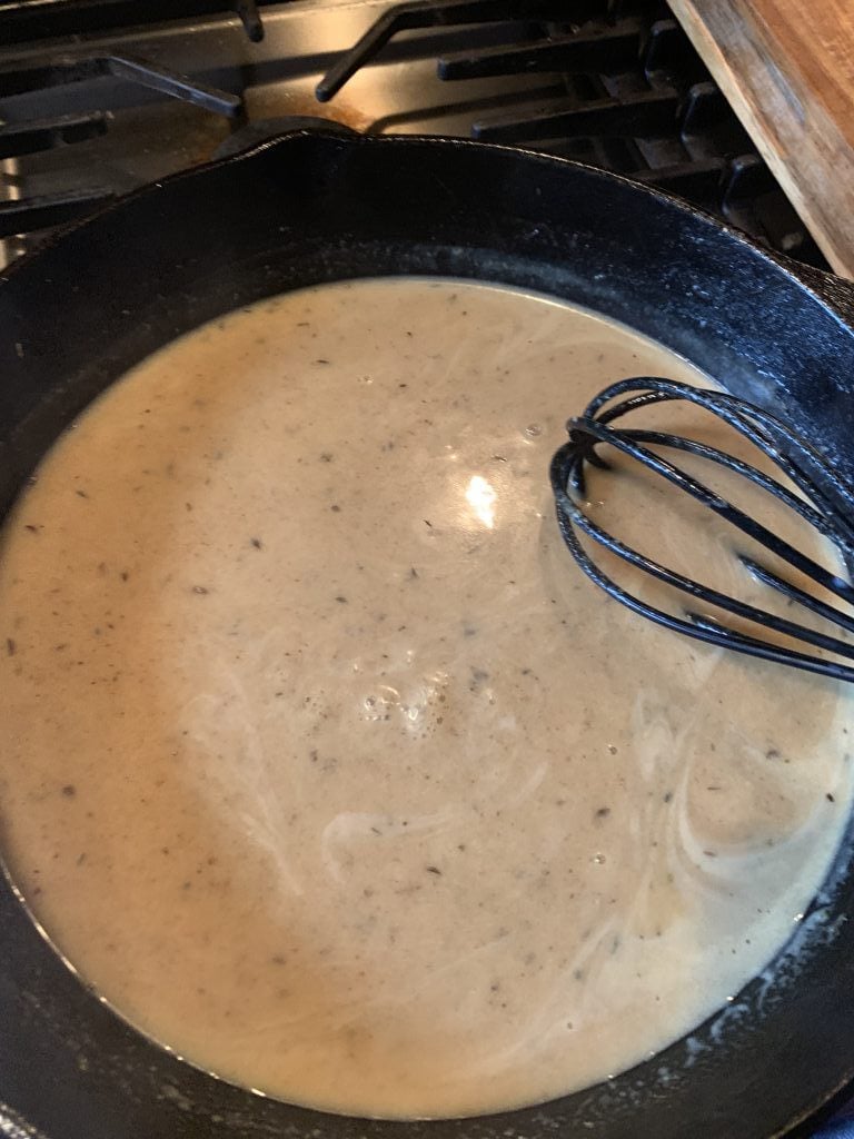 The mustard sauce in a pan with a whisk