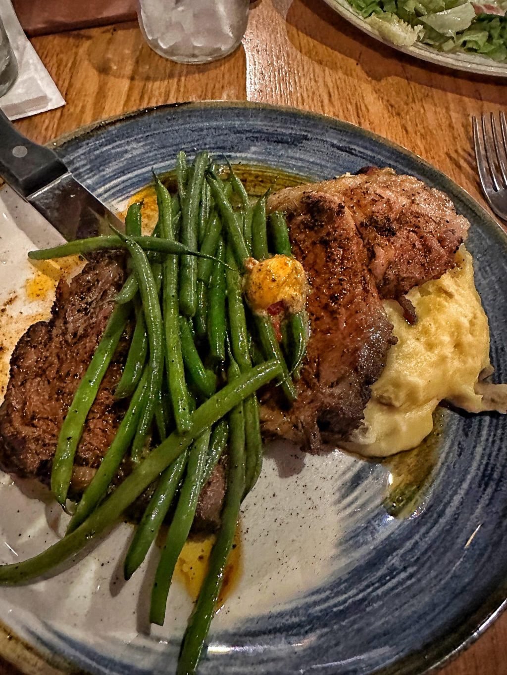 Steak with green beans, Cajun butter, and mashed potatoes