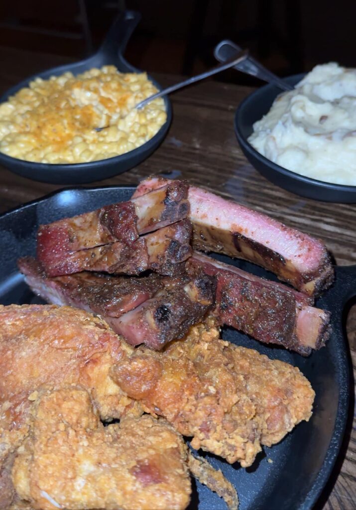 Fried chicken and ribs with mac and cheese and mashed potatoes in the background