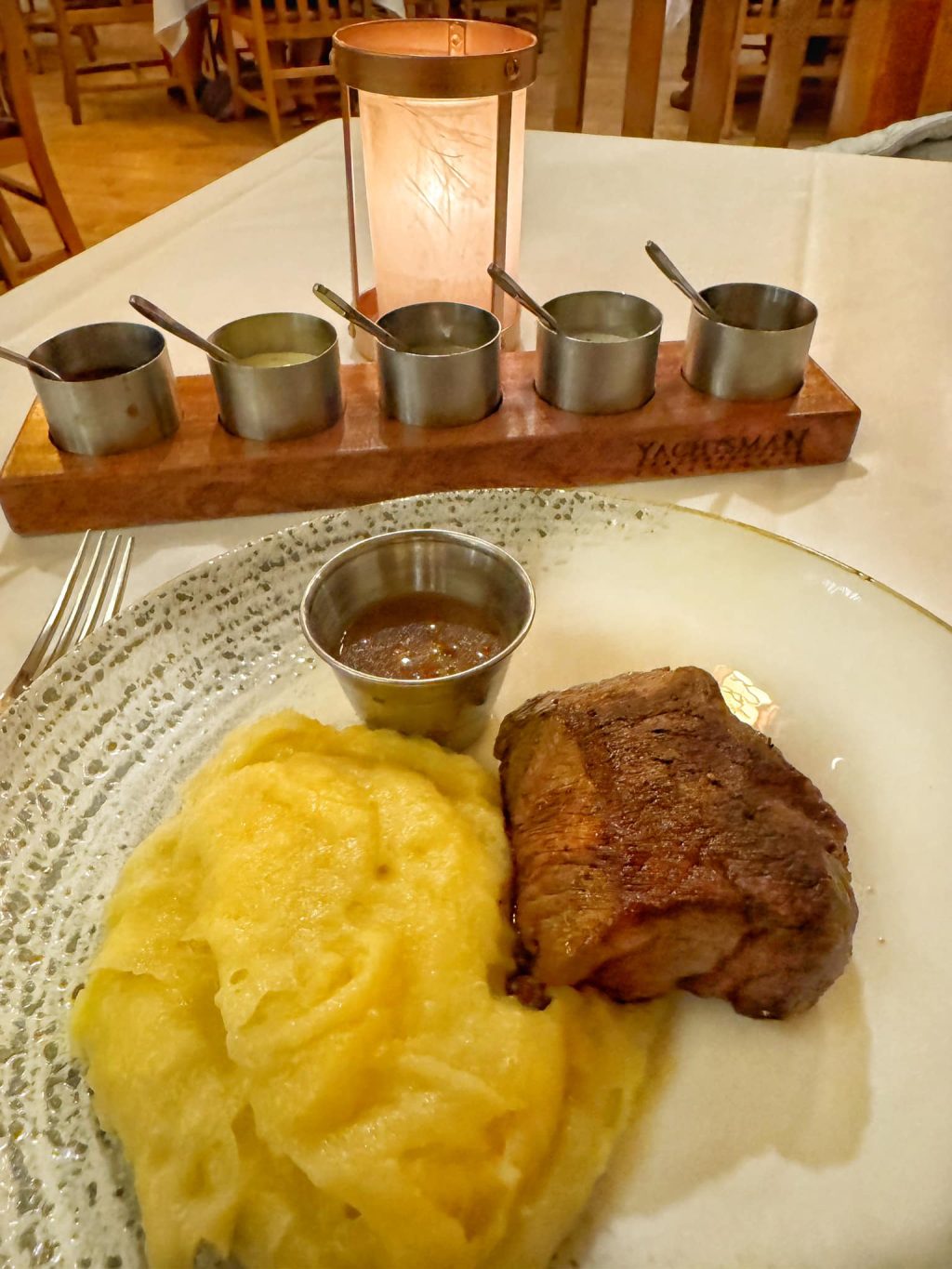 Filet Mignon on mashed potatoes with a fight of different sauces