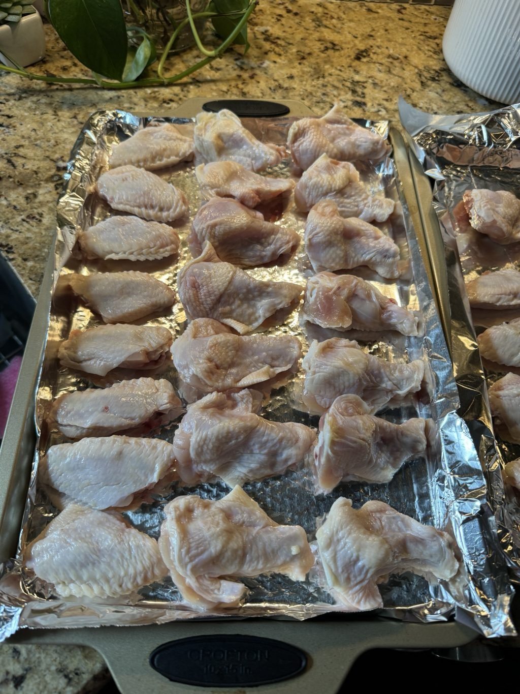 Raw chicken wings laid out on a baking sheet.