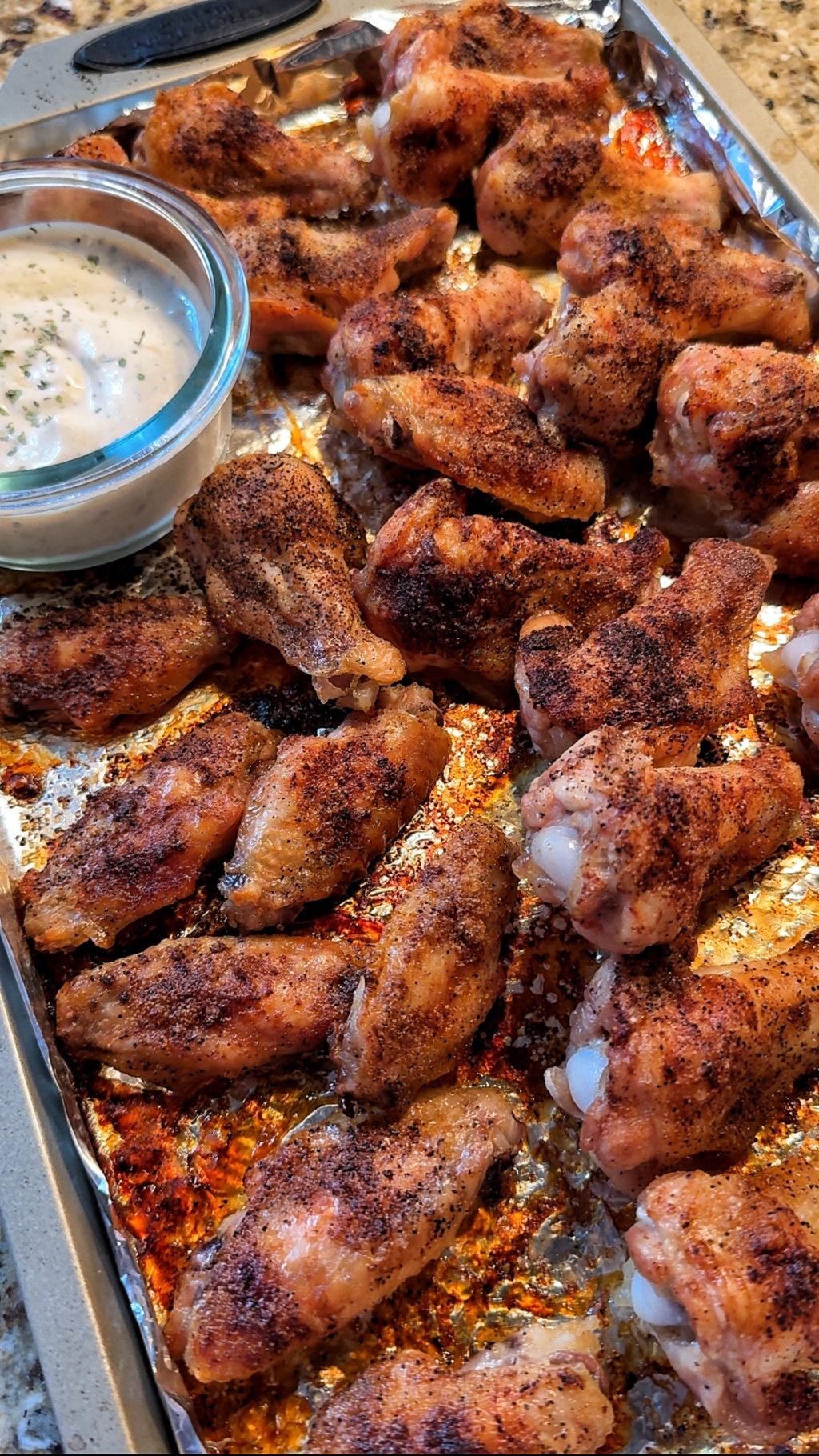 A close up of the crispy wings with dipping sauce