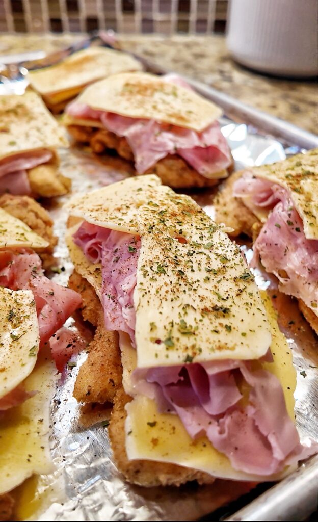 Seasoned cheese on top of ham and chicken