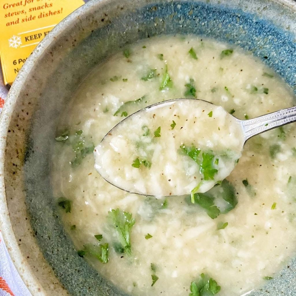 Dumpling soup with a spoon being raised from it