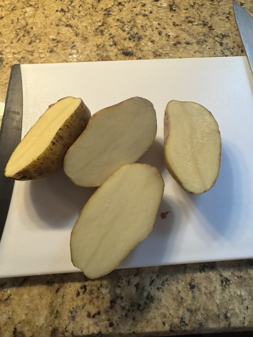 Two potatoes, each cut in half lengthwise