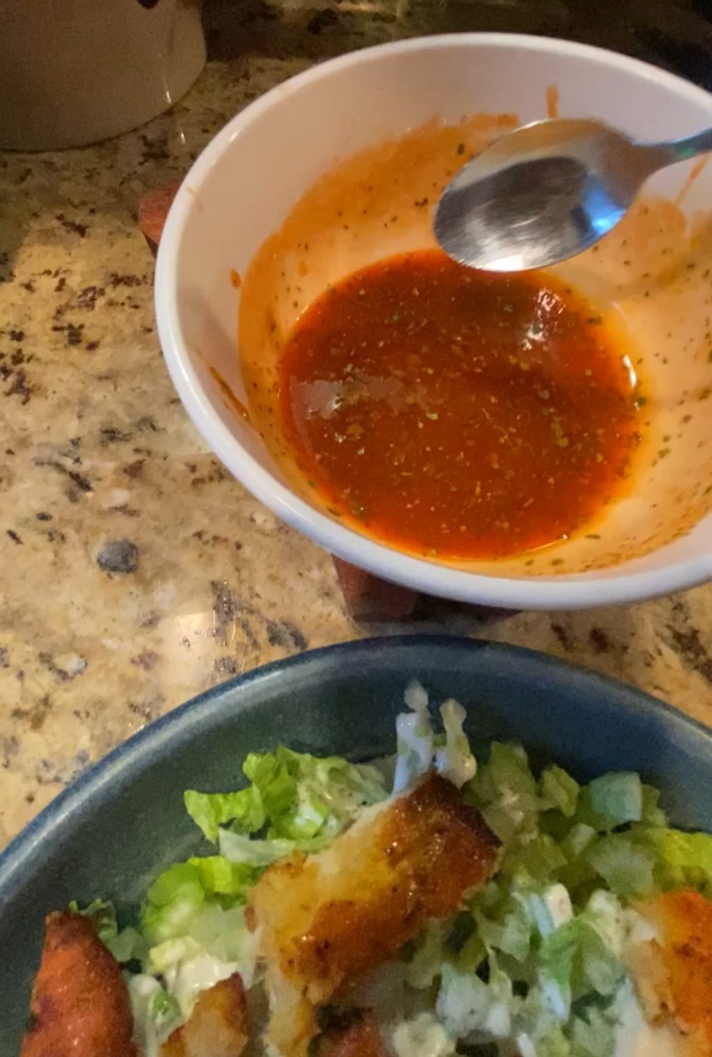 Red dressing about to be spooned on the salad