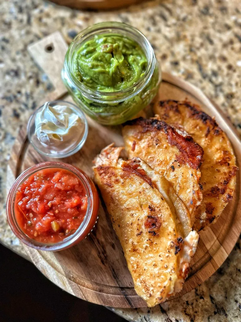 Crispy Chicken Tacos with salsa, sour cream, and guac