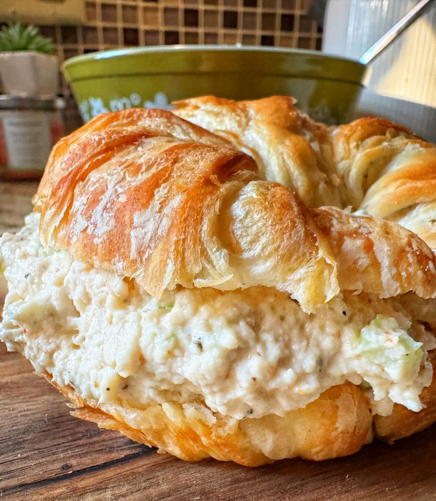 A close up of chicken salad in a croissant