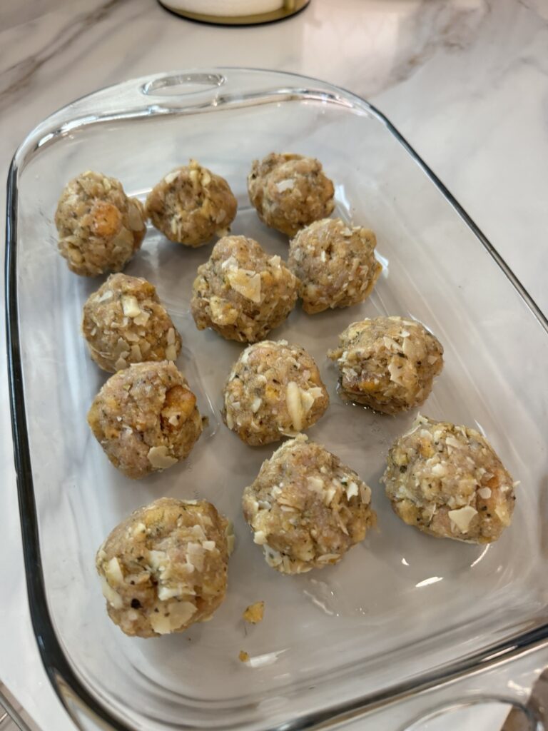 The meatballs in a glass baking dish before being cooked