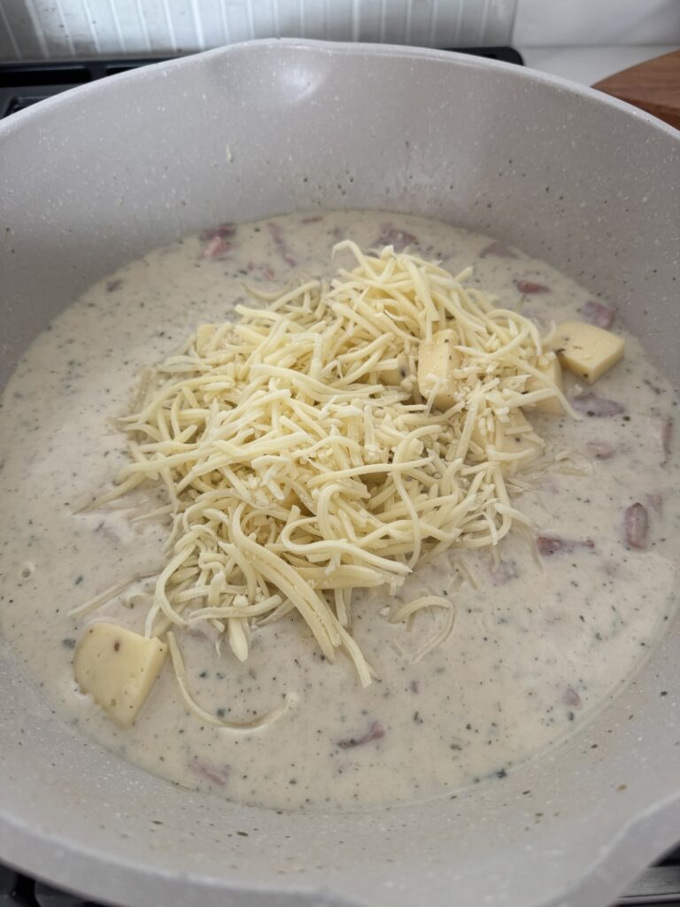Shredded cheese on top of the sauce mixture