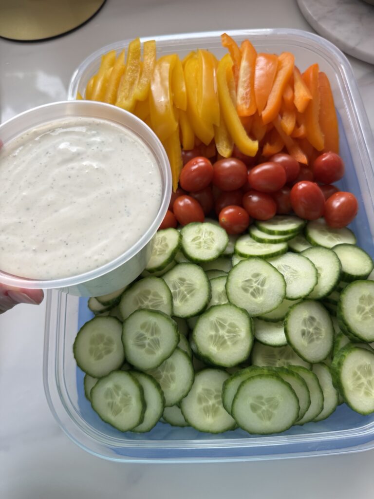 Ranch dressing held above chopped veggies