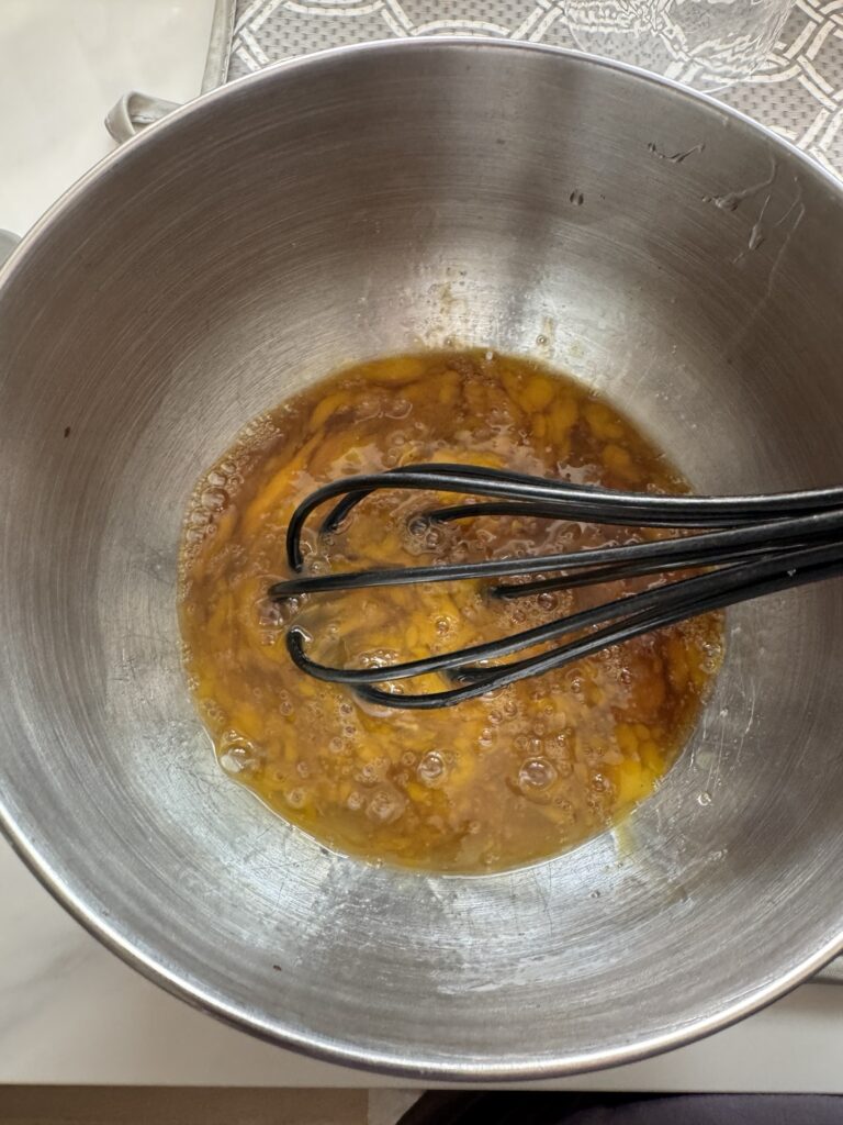 Egg and soy sauce mixture with a whisk in it