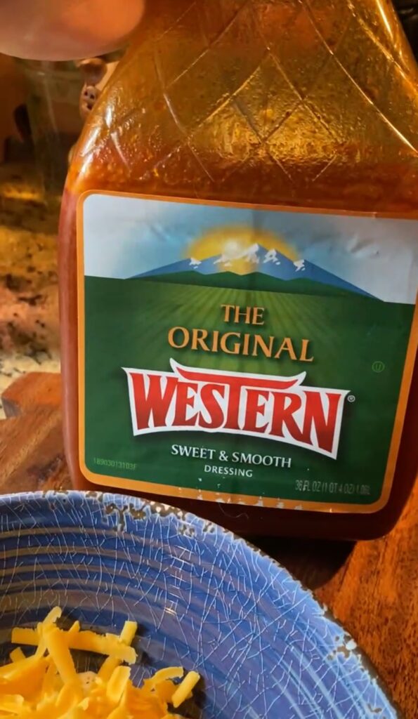 Western dressing next to a bowl of shredded cheese