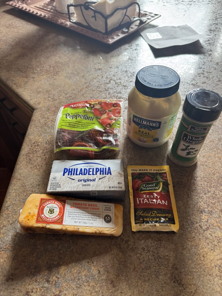 The ingredients for the dip, including the Zesty Italian dressing mix, cheese, oregano, pepperoni,cream cheese, and mayo