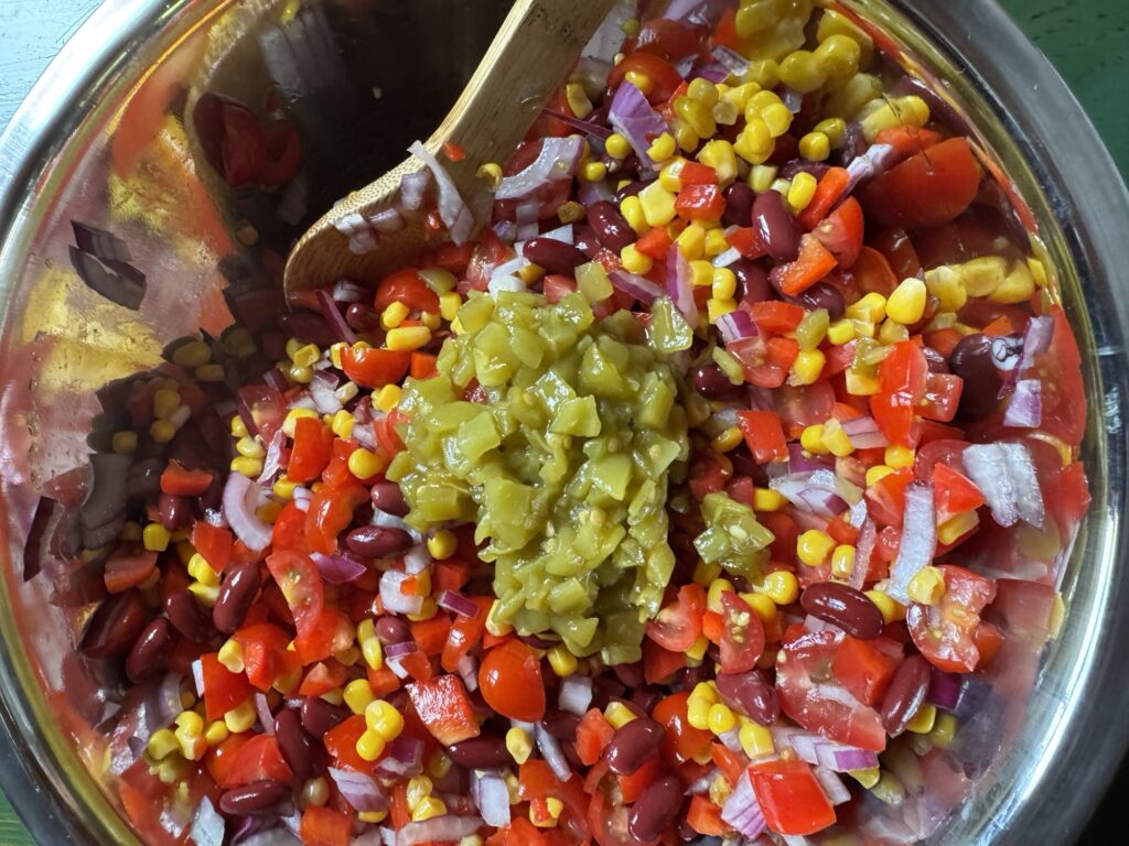The vegetables for the salad being mixed in a bowll