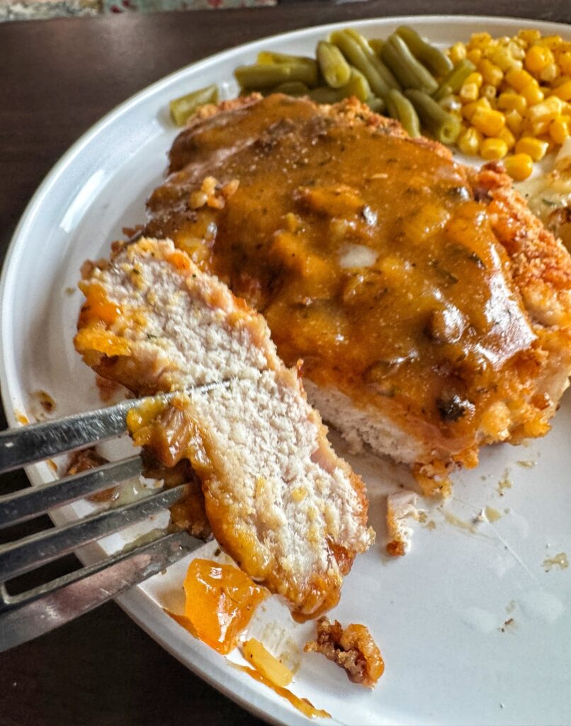A fork with a piece of the crispy chop on it