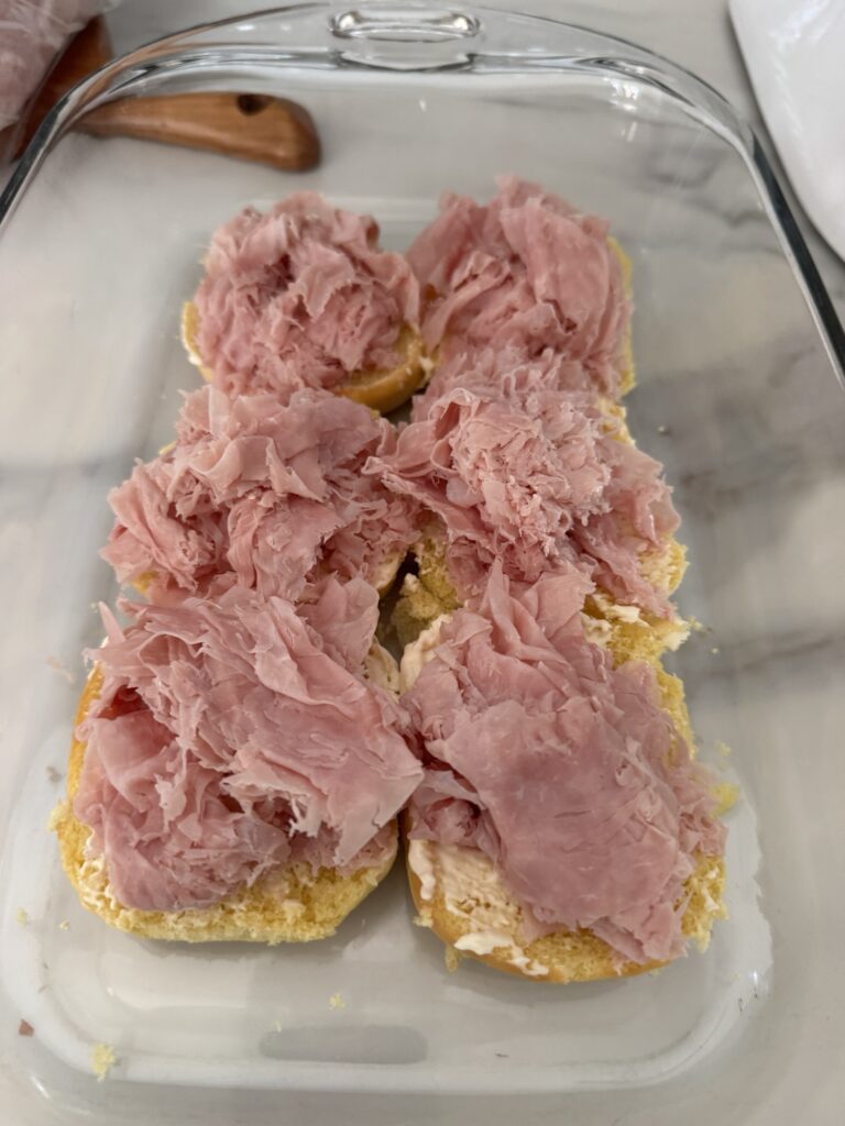 Deli meats on a slab of the bottom half of rollls