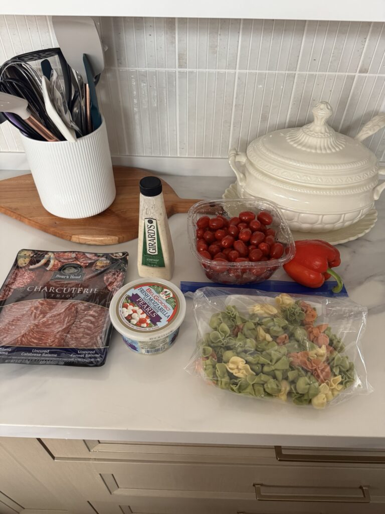 The ingredients for Tortellini Salad, including charcuterie, mozzarella, pepper, baby tomatoes, and tortellini