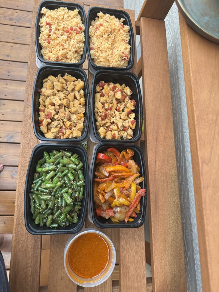 Two sets of pre-portioned meals, with separate containers for rice, chicken, green beans, and peppers