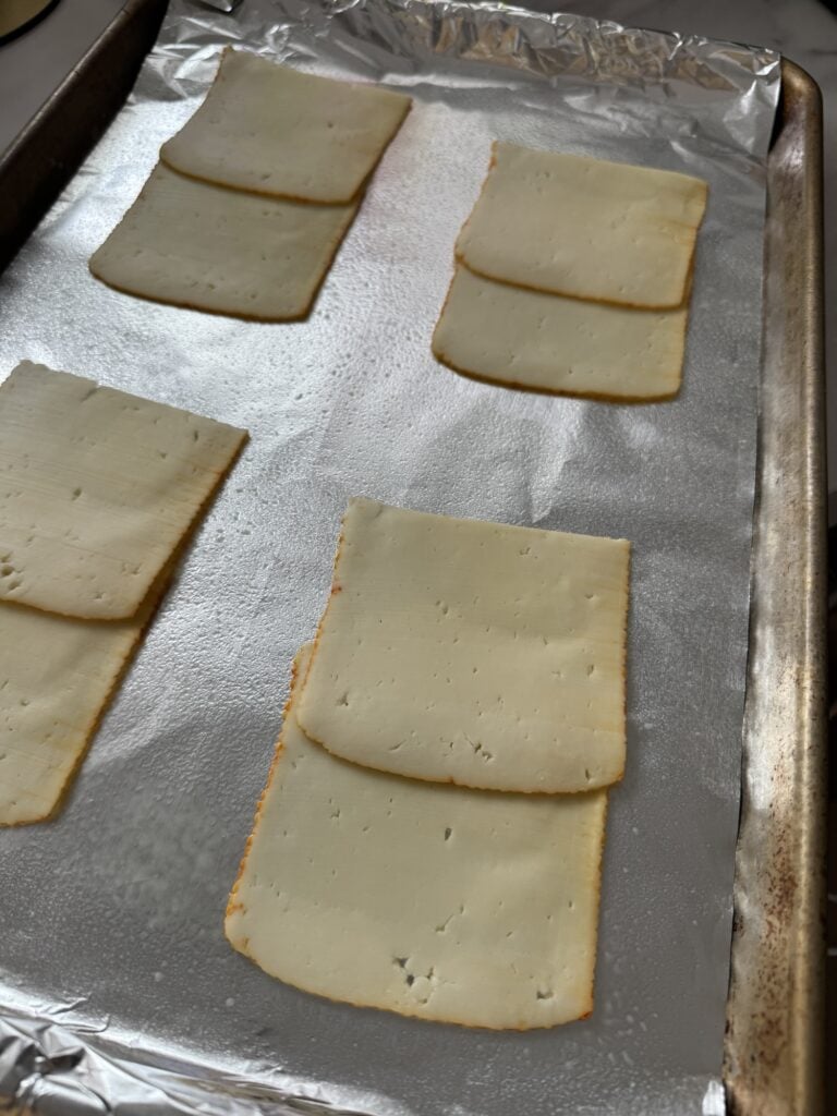 Slices of cheese on a baking sheet