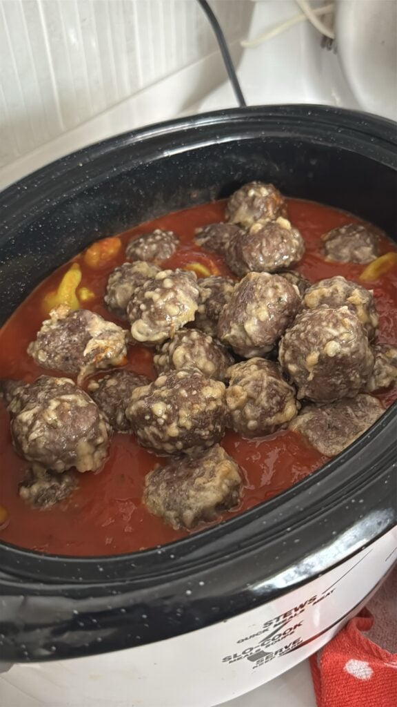 Meatballs added to the sauce in the slow cooker